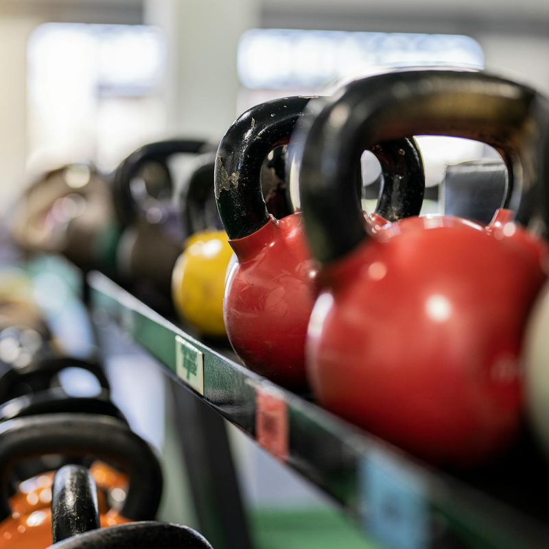 Close-up shot of a kettlebell on a wooden gym floor.