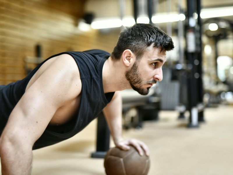 Man performing a controlled bodyweight exercise with intense focus.